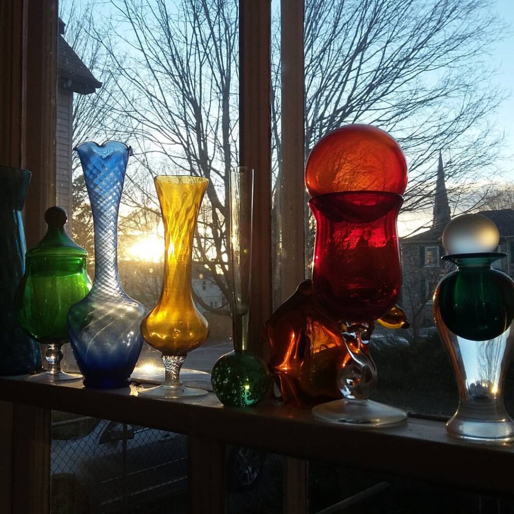 Coloured glassware gleaming in a window.