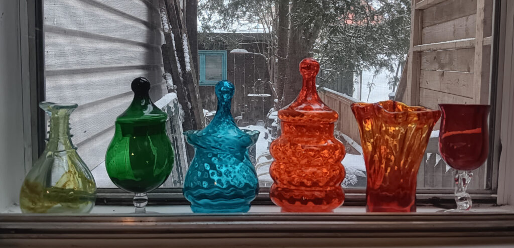 Coloured glass in a window with winter scene in the middle distance.